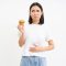Portrait of asian woman feeling pain in stomach, discomfort after food, holding cupcake and looking unhappy, white background.