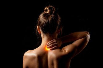 Back view of a bare-shouldered person with hands on the neck and a bright orange glow at the base of the neck, against a black background.
