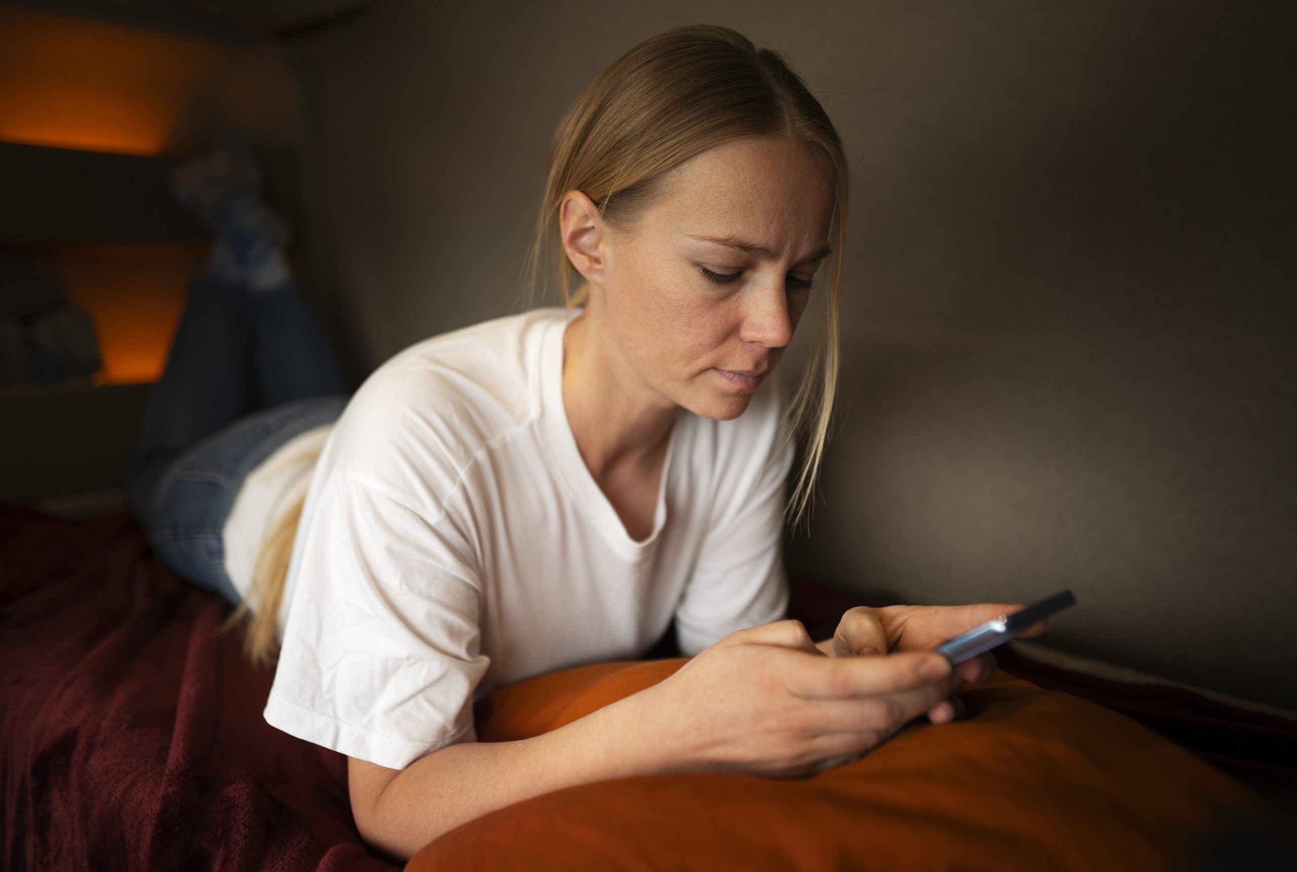 Žena před spánkem hraje na mobilu.