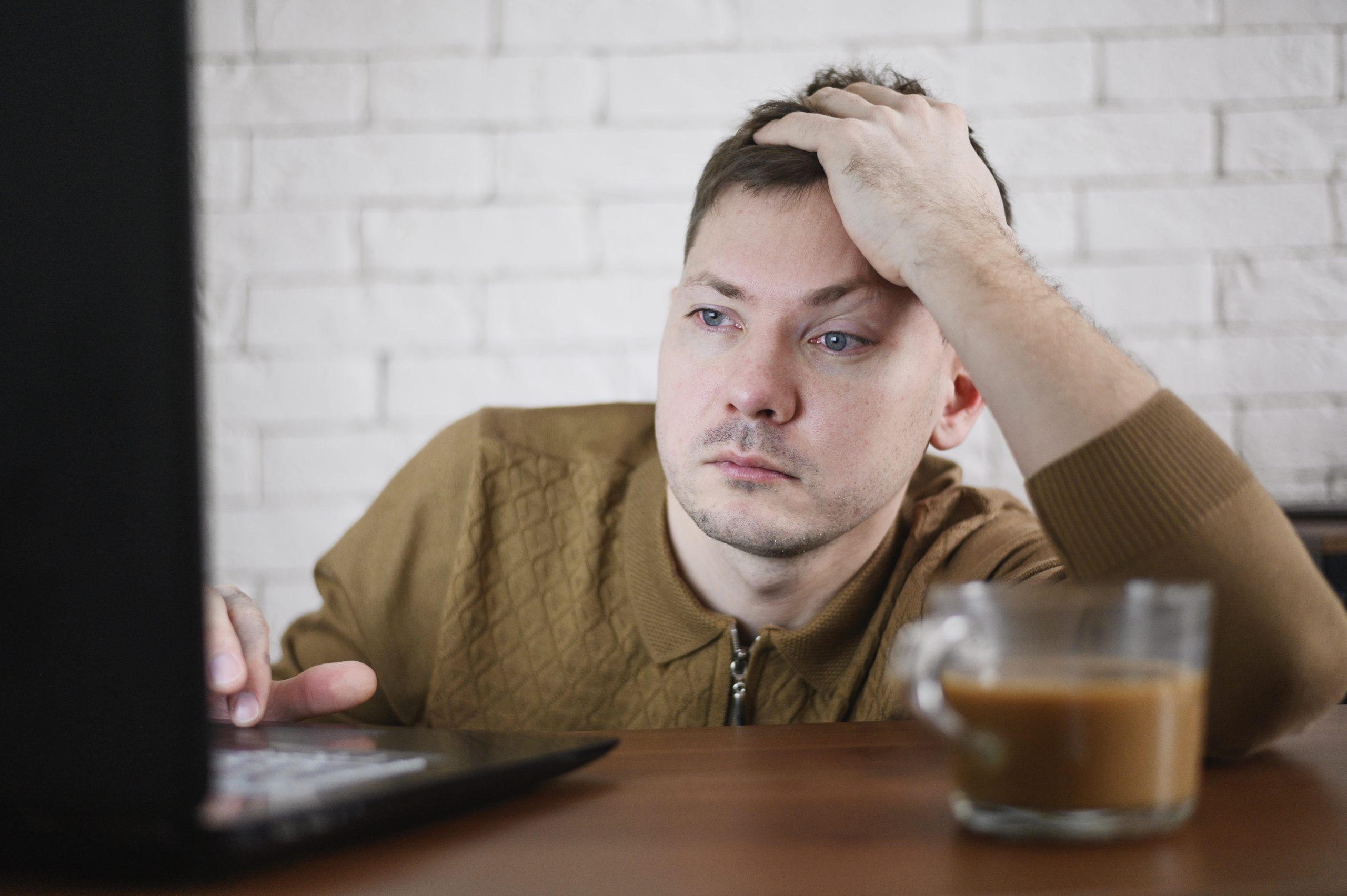 muž se cítí vyčerpaný a snaží se pracovat.